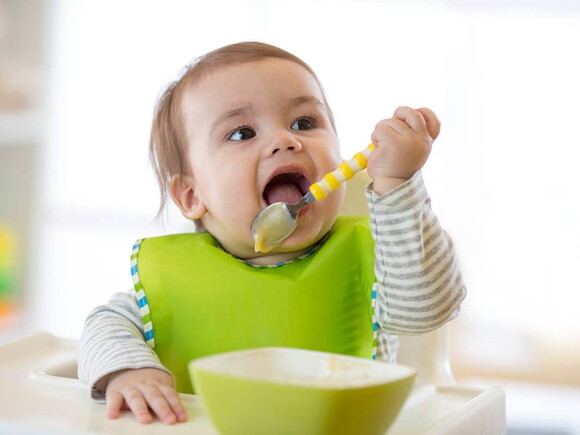 Bebé con babero comiendo