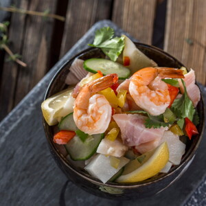 Un bowl con ceviche tropical y un limon al costado